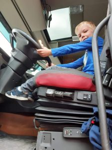 Jarno mocht even achter het stuur van de vrachtwagen waarmee de zorgunit werd gebracht.